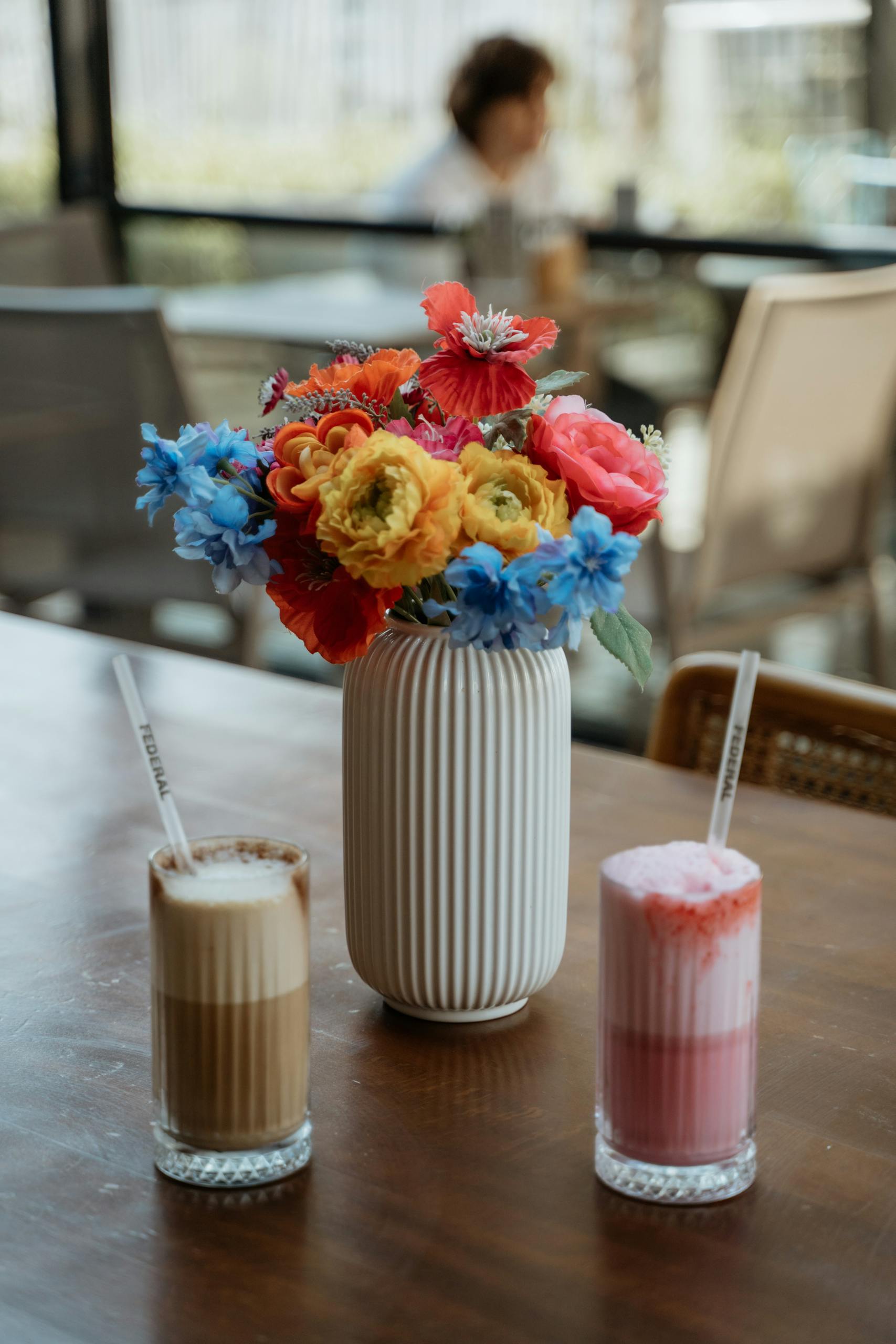 Vibrant bouquet and refreshing summer cocktails on a wooden table.